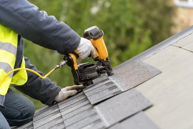 Professional roofer installing roof tiles with nail gun